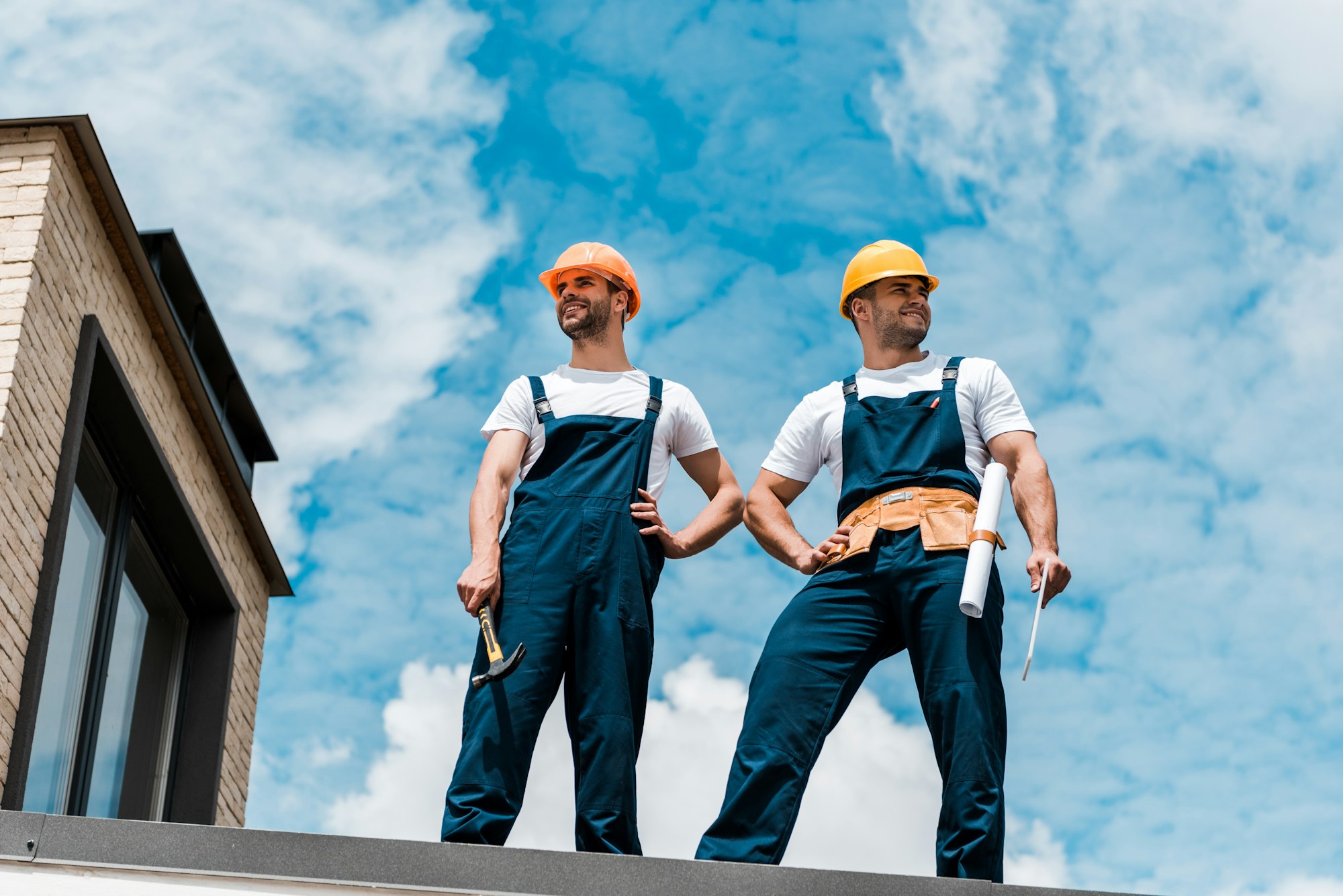 low angle view of handsome handymen standing with hands on hips