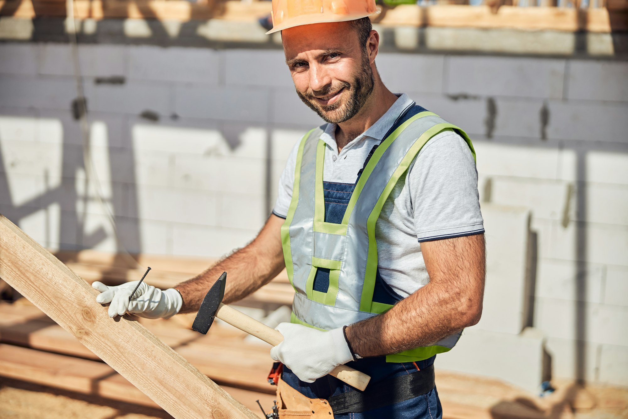 Portrait of delighted worker holding hammer in his hand